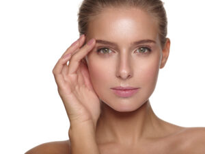 Youthful looking woman touching her brow after getting BOTOX in Livermore, CA