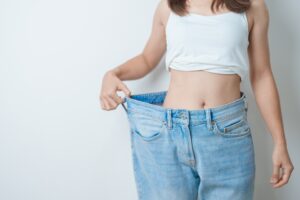 Slim woman in oversized jeans from weight loss with Semaglutide in Livermore, CA