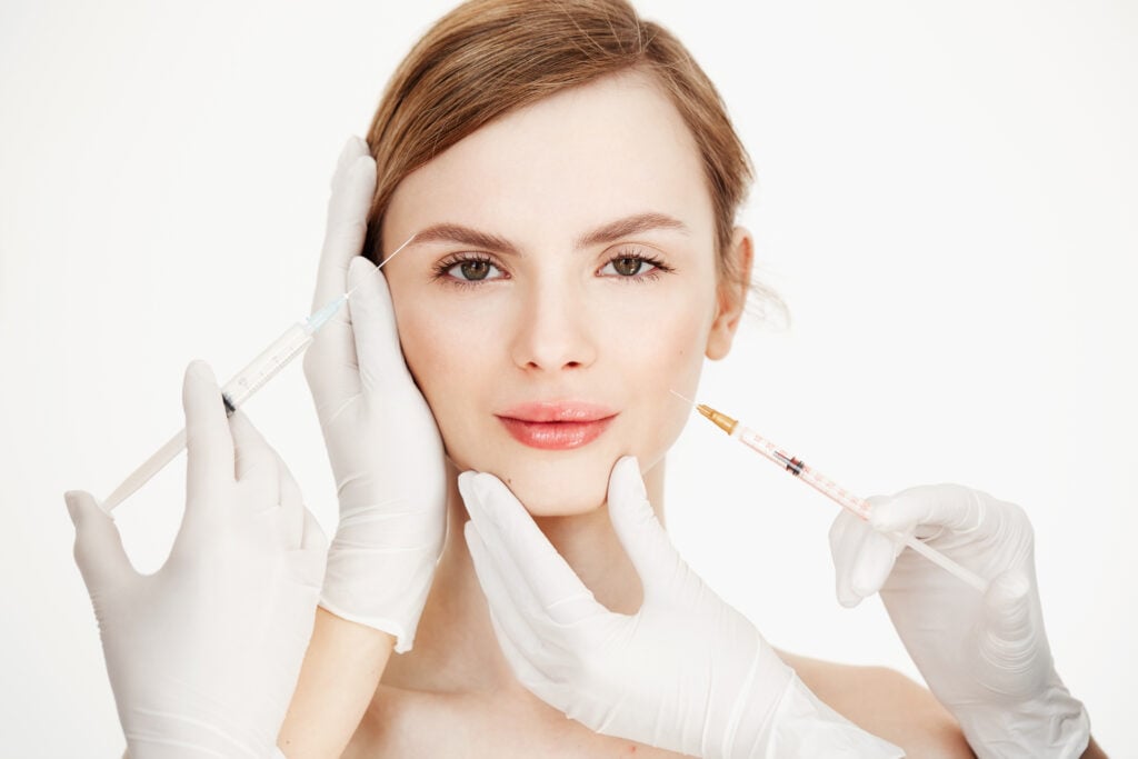 cosmetologists hands making medical botox injections beautiful blonde skin lifting facial treatment beauty spa